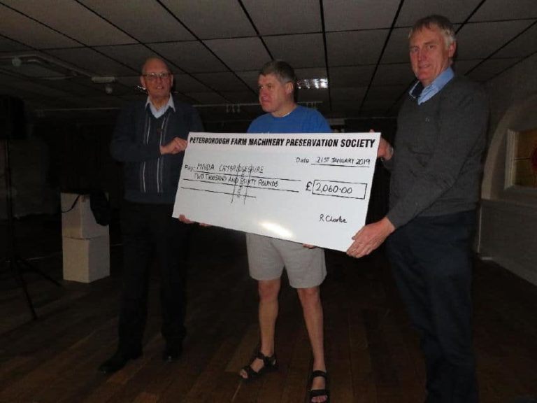 a photo of a group people holding a cheque 