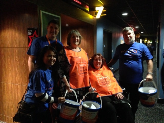 a group of people wearing mnd association t-shirts with money buckets