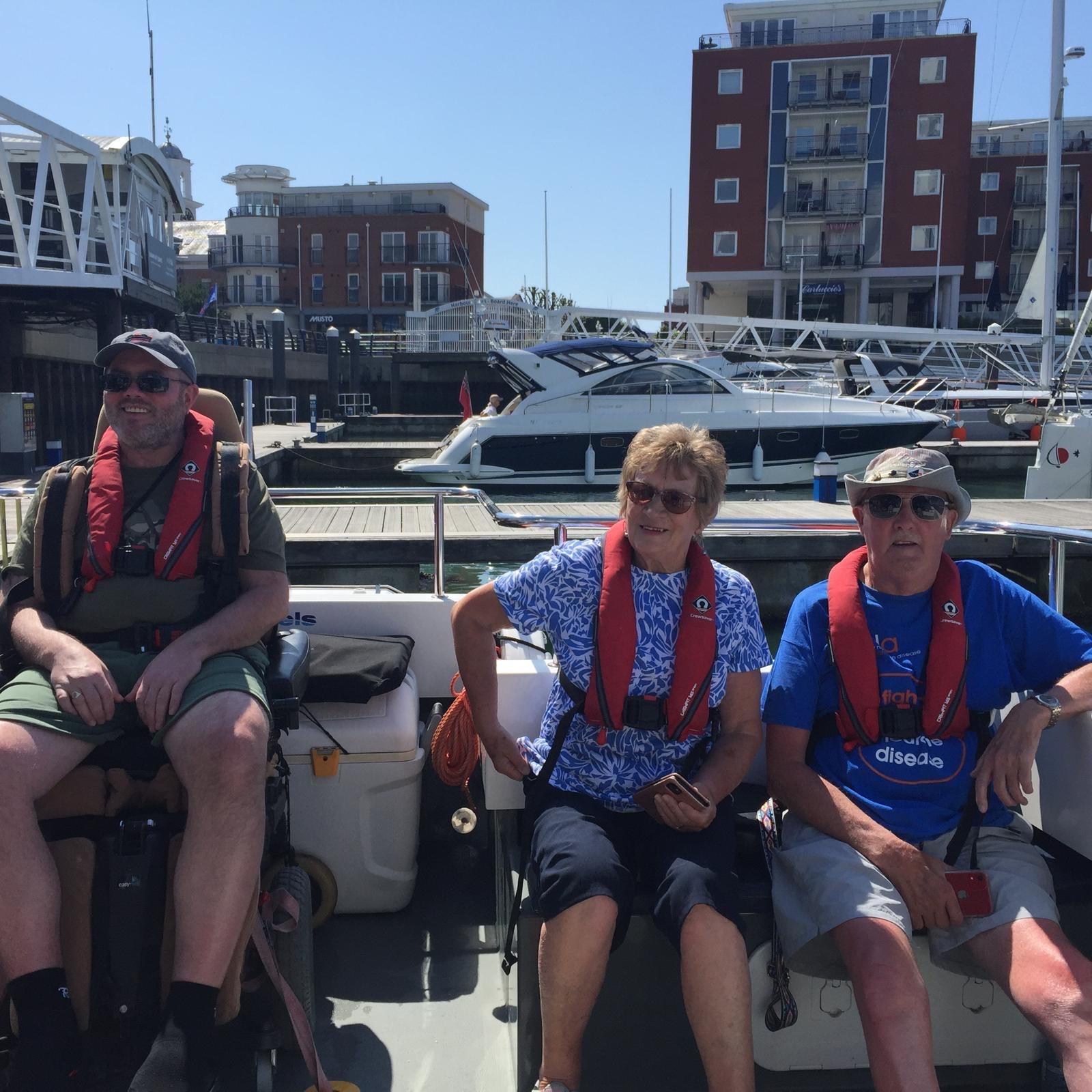 MND Association volunteers on a boat with life-jackets.