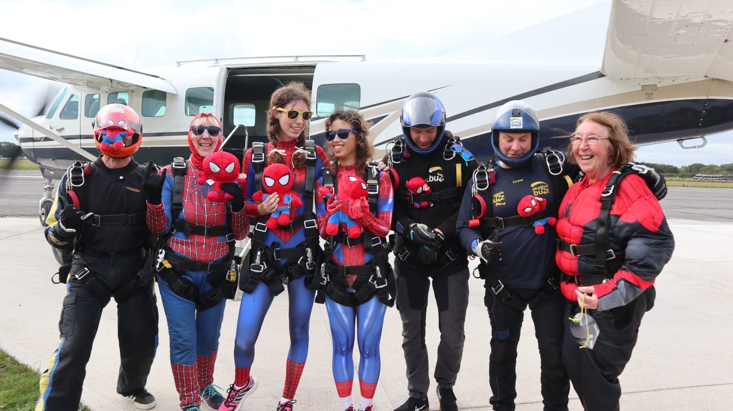 Seven people dressed up as Spiderman having completed a fundraising skydive
