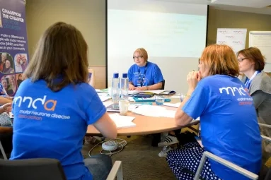 Volunteers gathered around a table at a meeting.