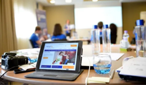 Open laptop in a room during training for Association Visitors